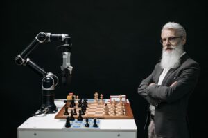 A robotic arm and a bearded man engaged in a strategic chess game highlighting technology and innovation.